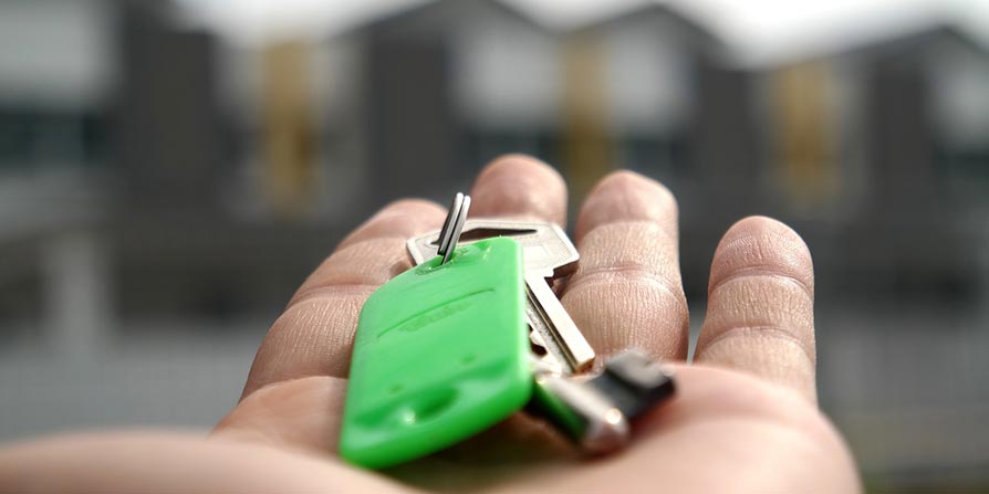 Hand holding house keys for a new home