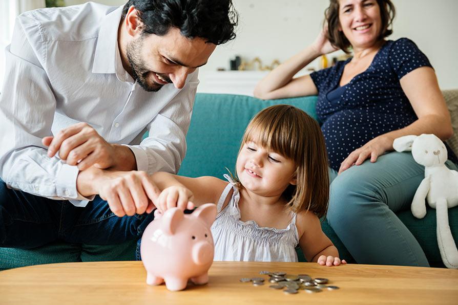 Family living in an energy efficient home with a piggy bank saving money Family living in an energy efficient home with a piggy bank saving money