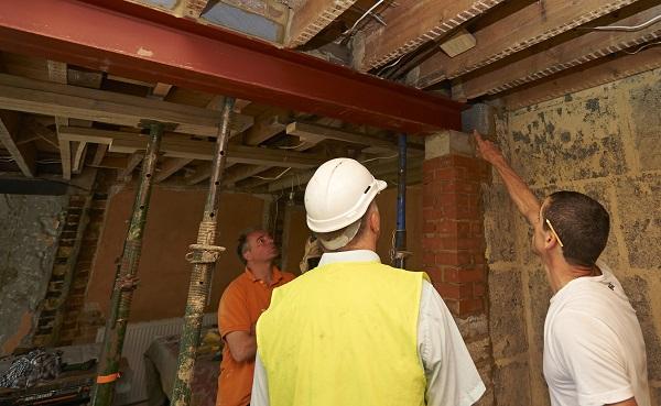 Builders pointing at beams in the roof