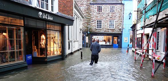 Picture of man walking down a flooded street