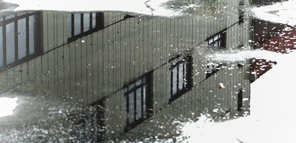 Puddle with rain and reflection of building