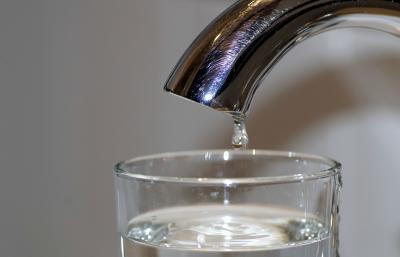 Tap dripping water into glass