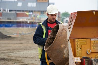 Image of a man next to a mortar mixer on a construction site