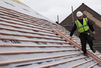 Roofing contractor working on roof