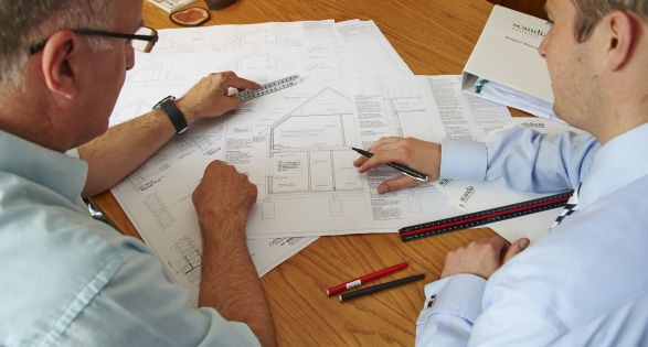 Two men looking at building design plans. Local authority building control (LABC)